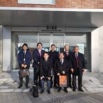 関ヶ原町役場の前で記念撮影する名張市議会産業建設委員会のメンバーと名張市議会議員小林勝