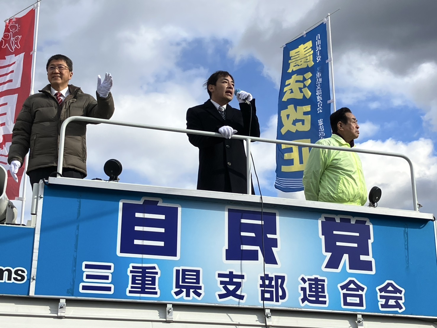 自由民主党の街宣車の上で街頭演説をする名張市議会議員の小林勝